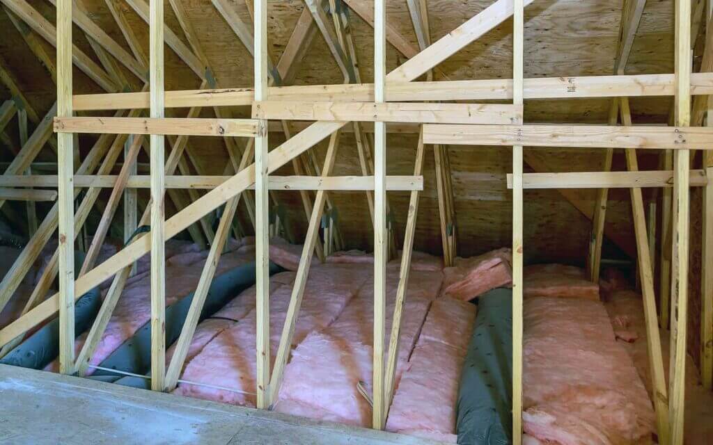 Insulated attic with wooden beams.