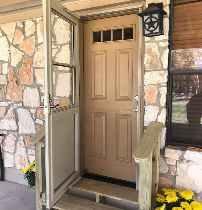 Elegant wooden door installed on a home with stone facade, enhancing curb appeal in San Antonio.