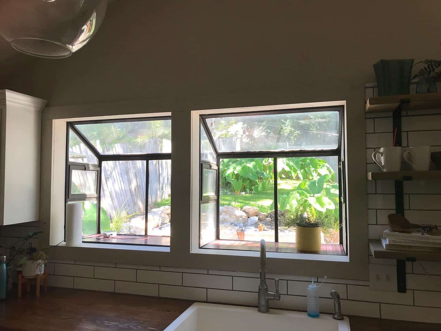 Spacious kitchen windows providing a view of a green garden before renovation in San Antonio.