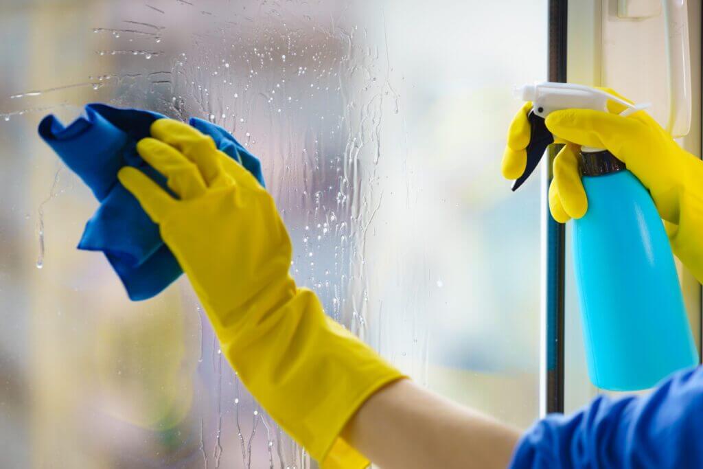 Person cleaning window to prevent mold growth