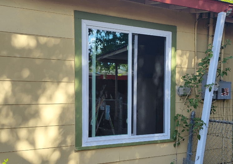 Newly installed double-pane window on a yellow house, reflecting quality and efficiency in San Antonio, Texas