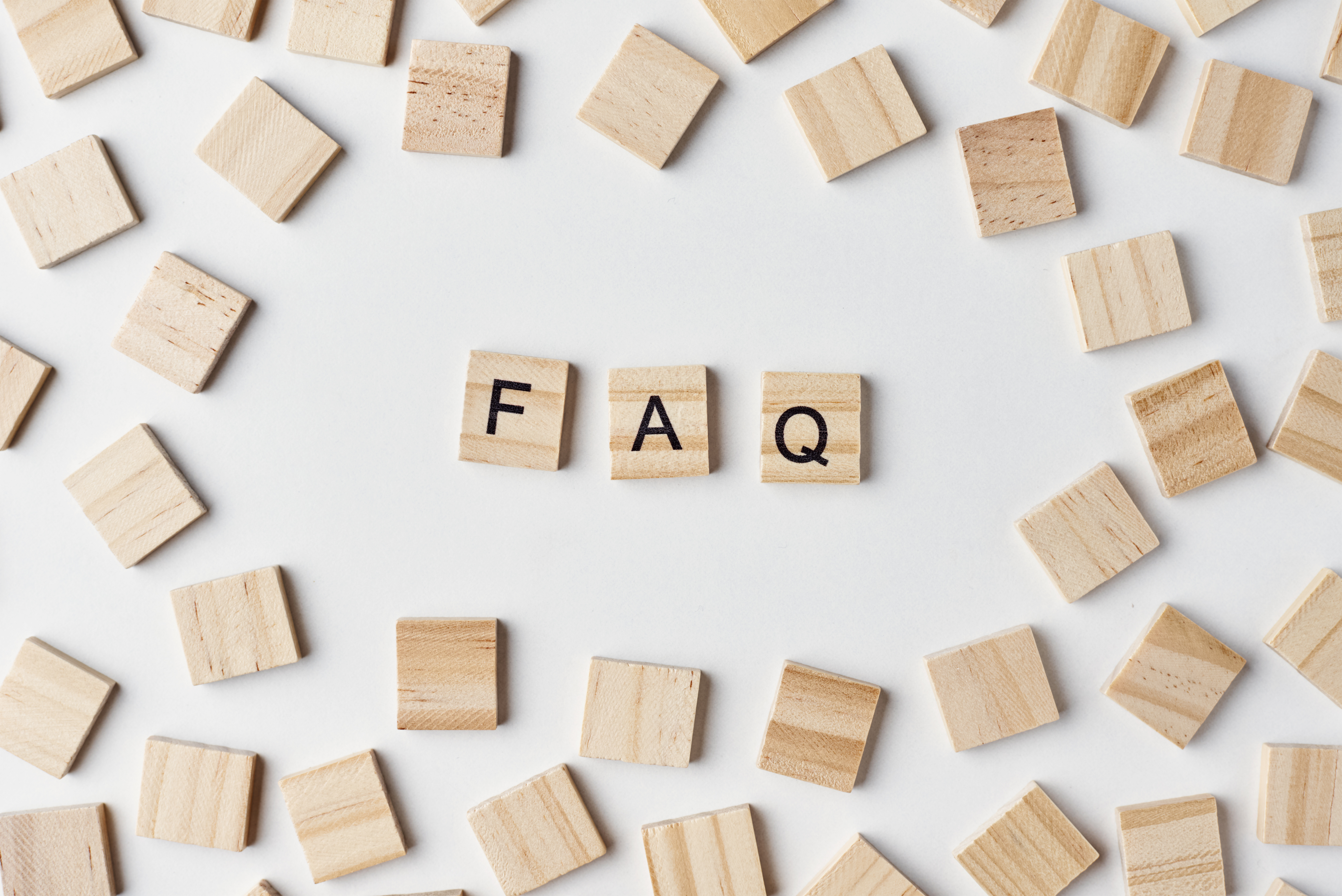 Wooden letter tiles spelling out “FAQ”.
