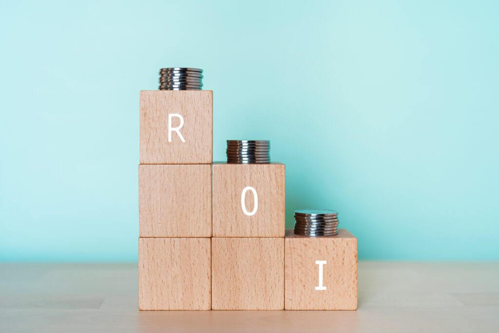 Wooden blocks with the letters R, O, I and stacks of coins on top