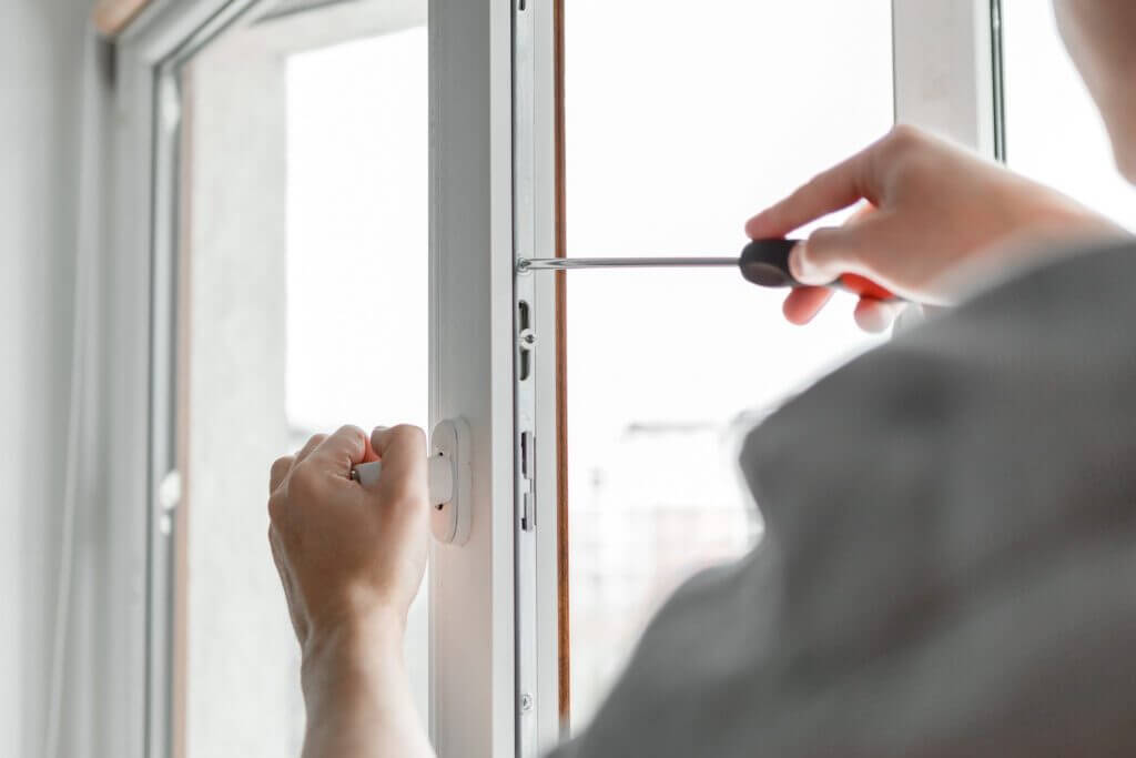 Handyman replacing window hardware to ease opening.