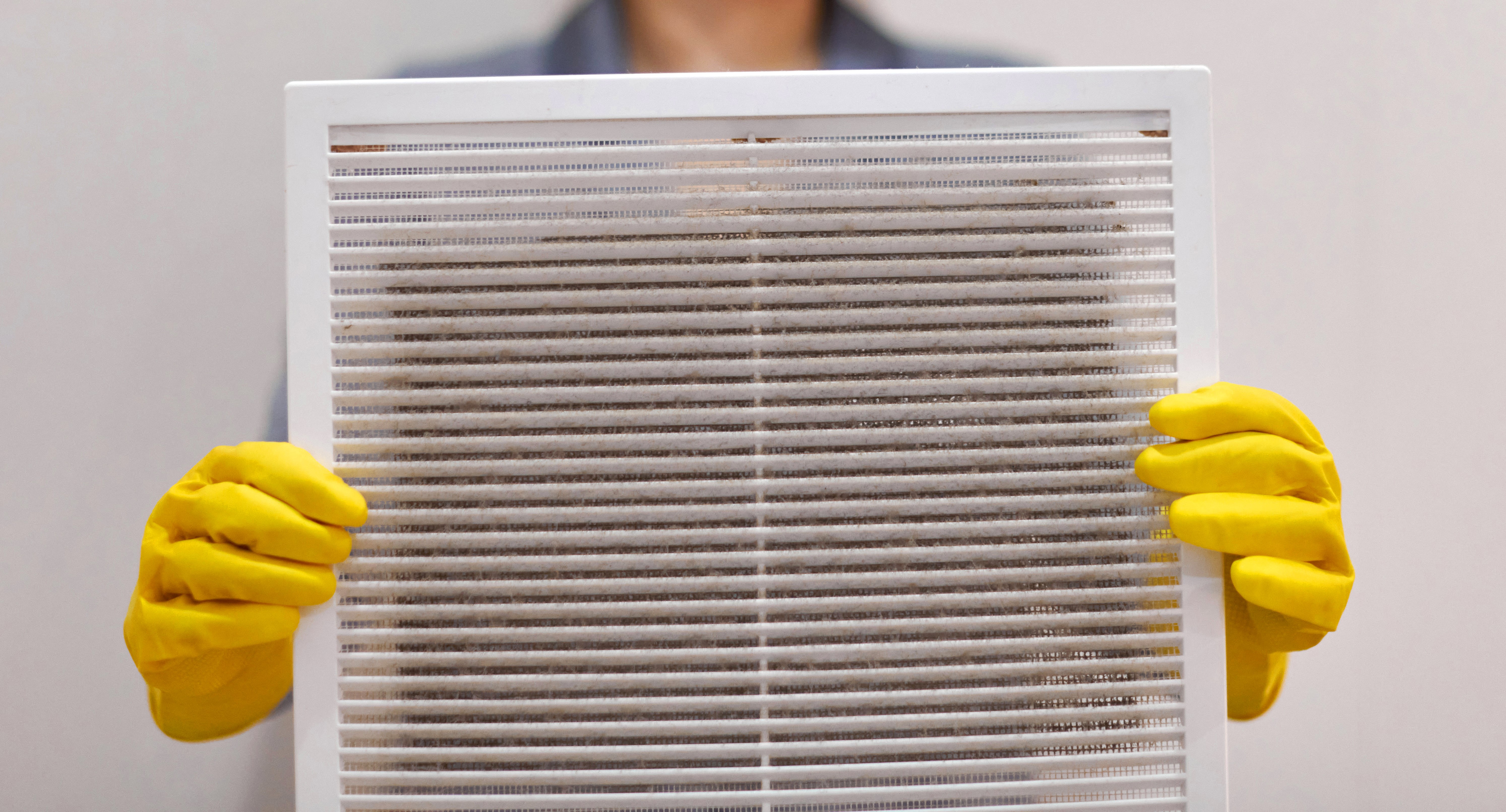 Person holding a dirty HVAC filter.