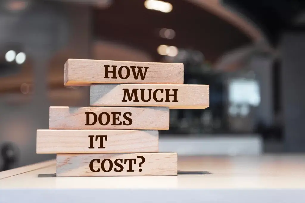 Wooden blocks stacked with the words 'How Much Does It Cost?