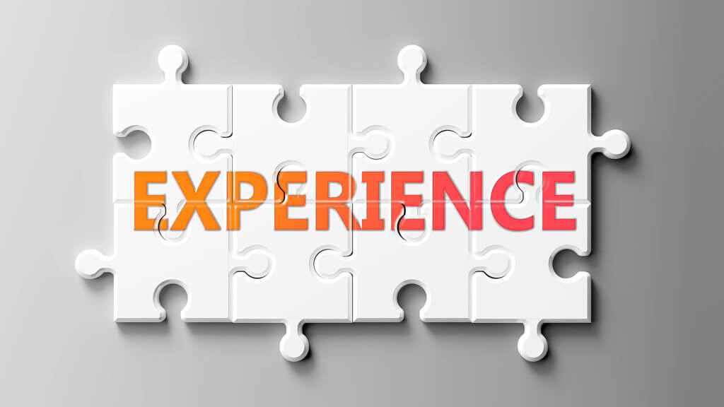 A puzzle with white pieces and the word 'EXPERIENCE' written across them in bold, colorful letters.