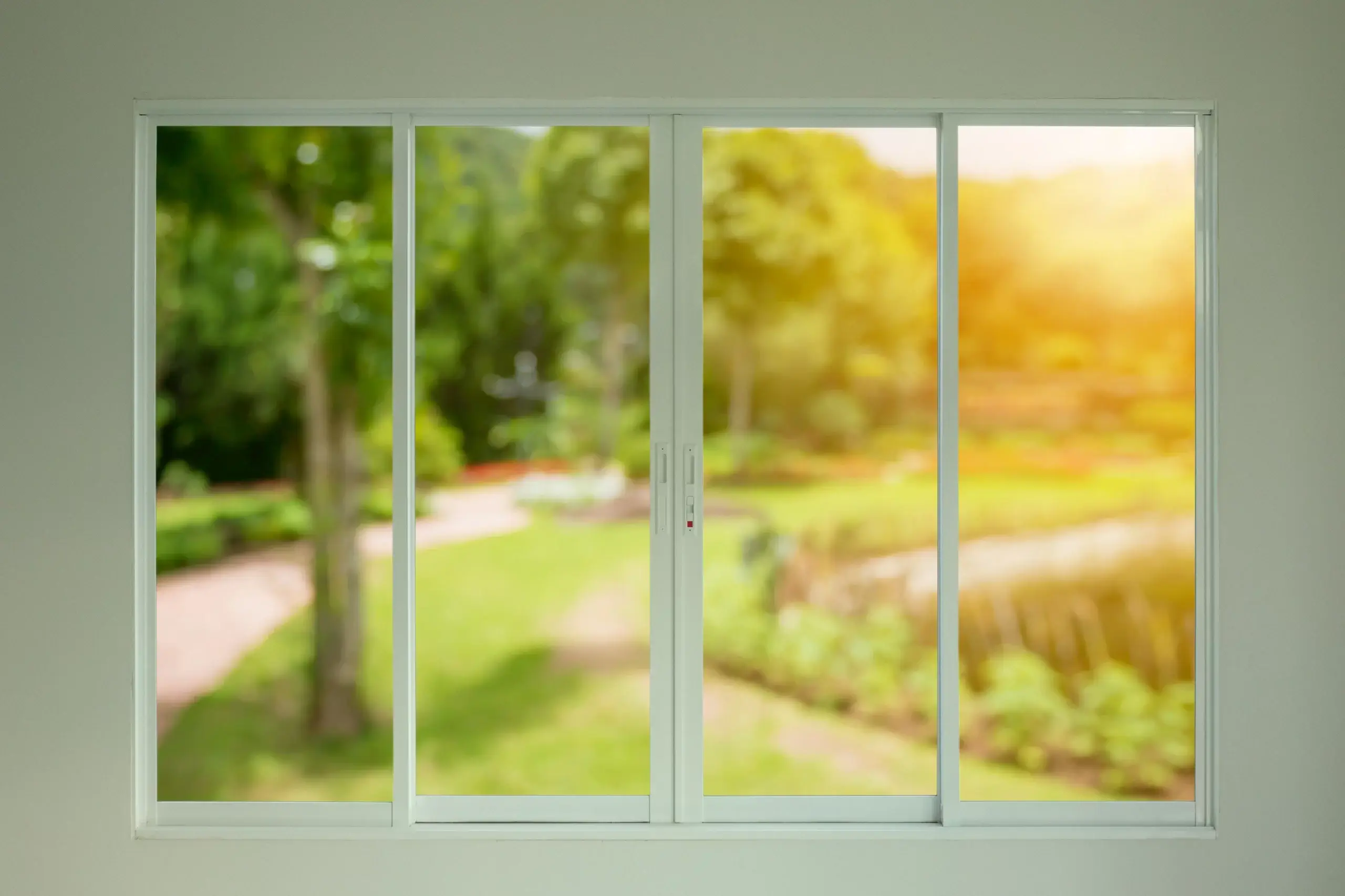 Sliding glass door with a clear view of a sunlit garden, comparing low-e glass versus clear glass for homes in San Antonio and Corpus Christi